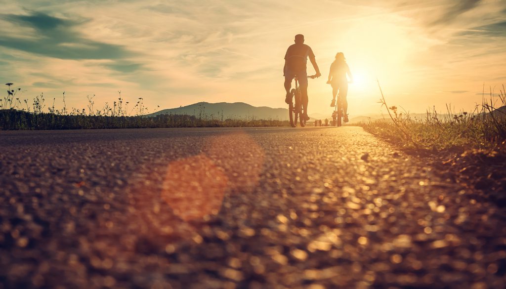 Cyclists are on the sunset road