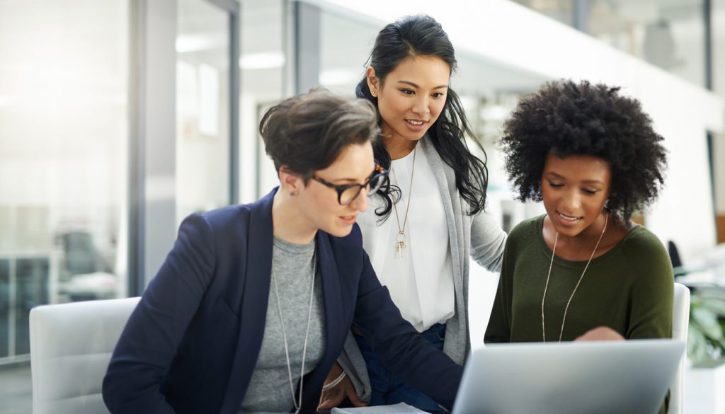 Shot of a group of businesswomen using a laptop during a meeting at work