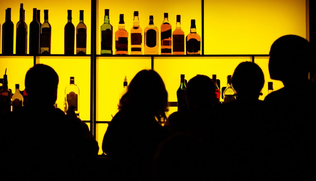 Silhouettes of people at a cocktail bar