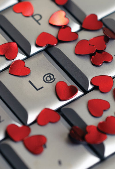 This is a photo of a keyboard covered with heart-shaped confetti. 