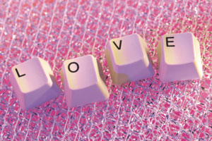 photo of computer keys that spell out the word love on some pink lace
