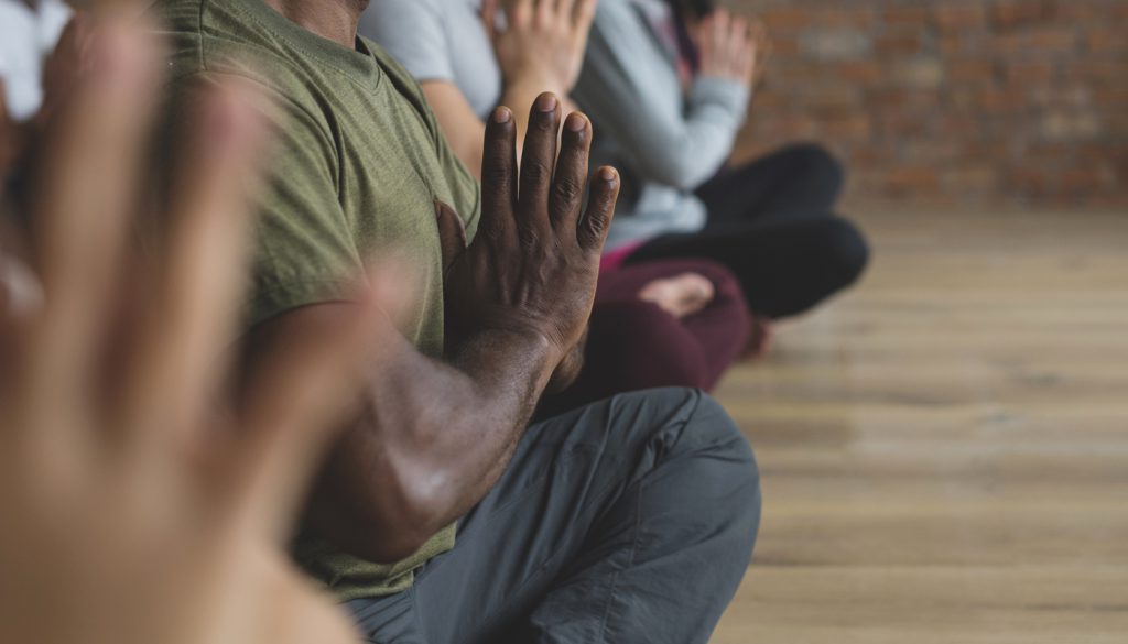 A diverse group of people in a yoga class