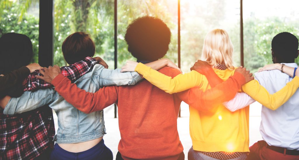 This is a photo of a group of people with their arms around each other.