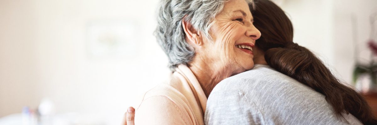 Shot of a senior woman hugging a young woman in a retirement home