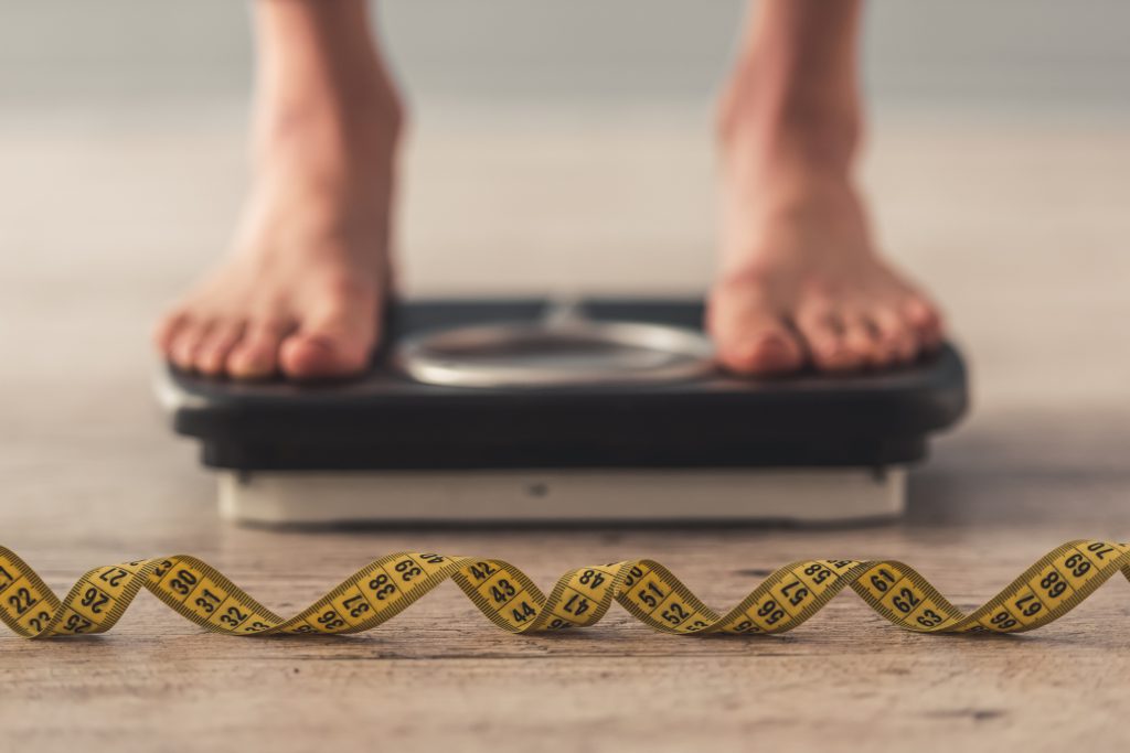 Feet on scale with tape measure in front