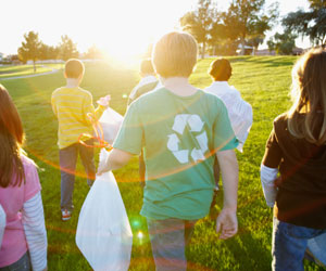 This is a photo of kids picking up trash in a field.