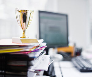 This is a photo of a tiny trophy on top of a stack of office papers.