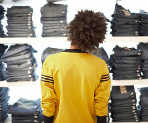 This is a photo of a young man trying to decide on a pair of jeans.