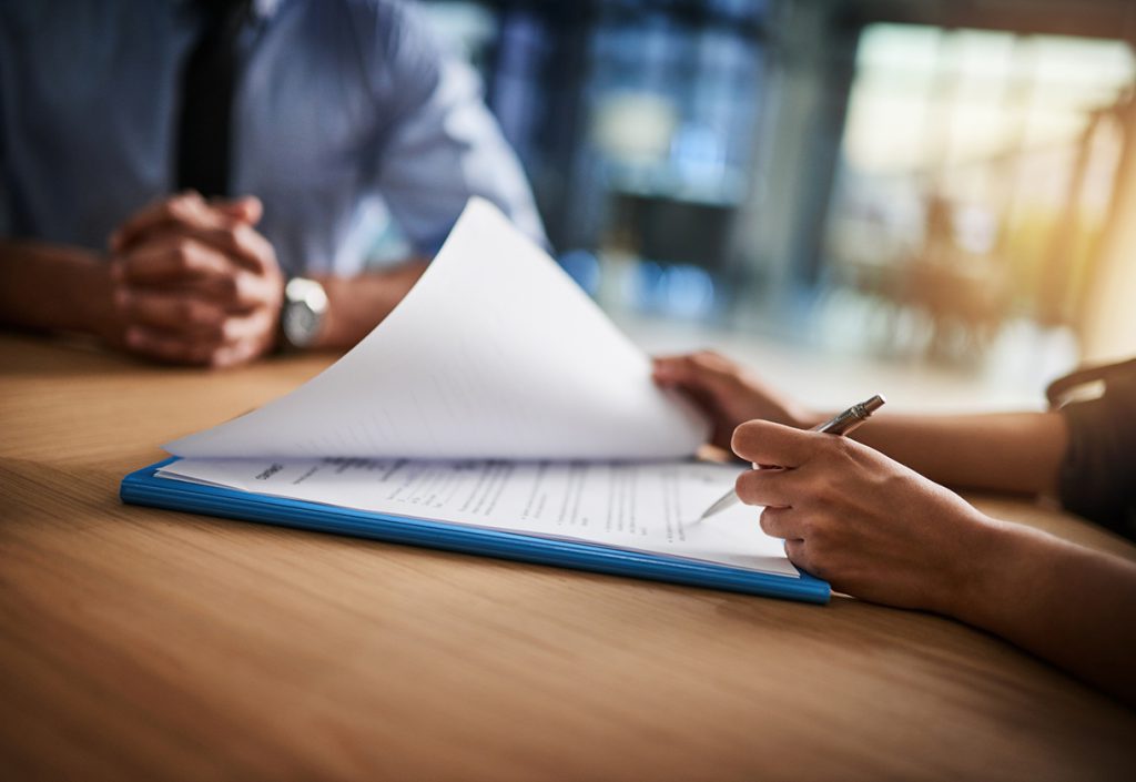 Cropped shot of a man and woman completing paperwork together at a desk