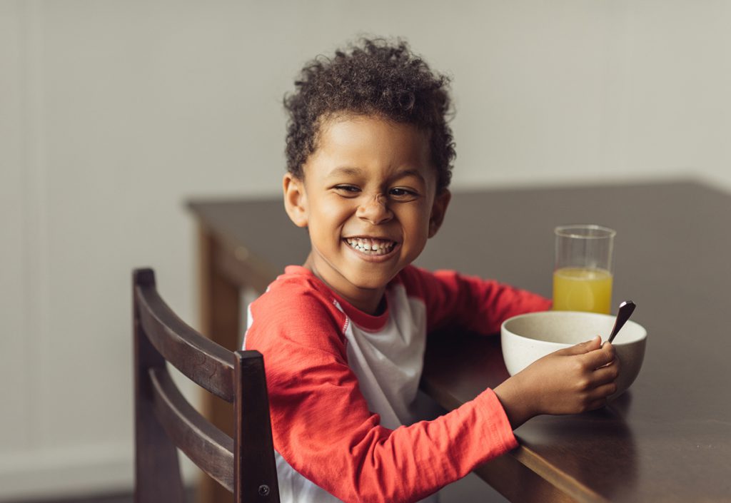 This is a young boy eating breakfast