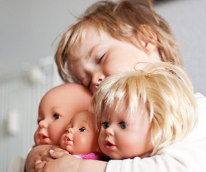 This is a photo of a child holding some dolls.