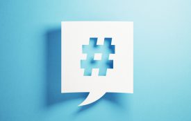 White chat bubble containing a hashtag, against a blue background.