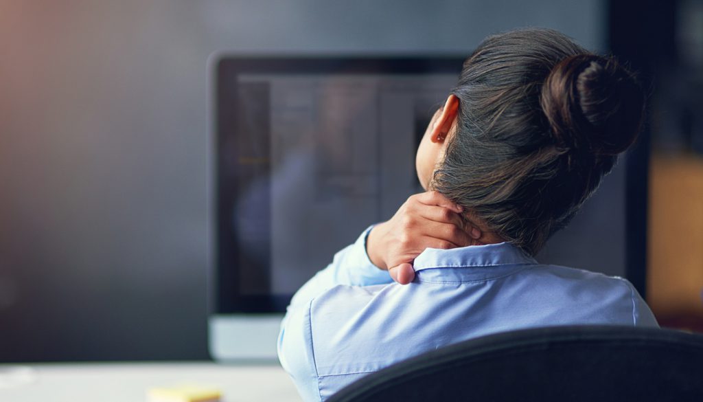 This is a photo of a woman in the office who is suffering from neck pain