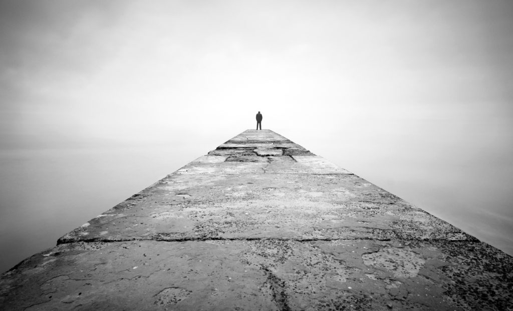 Man alone on the edge of a pier