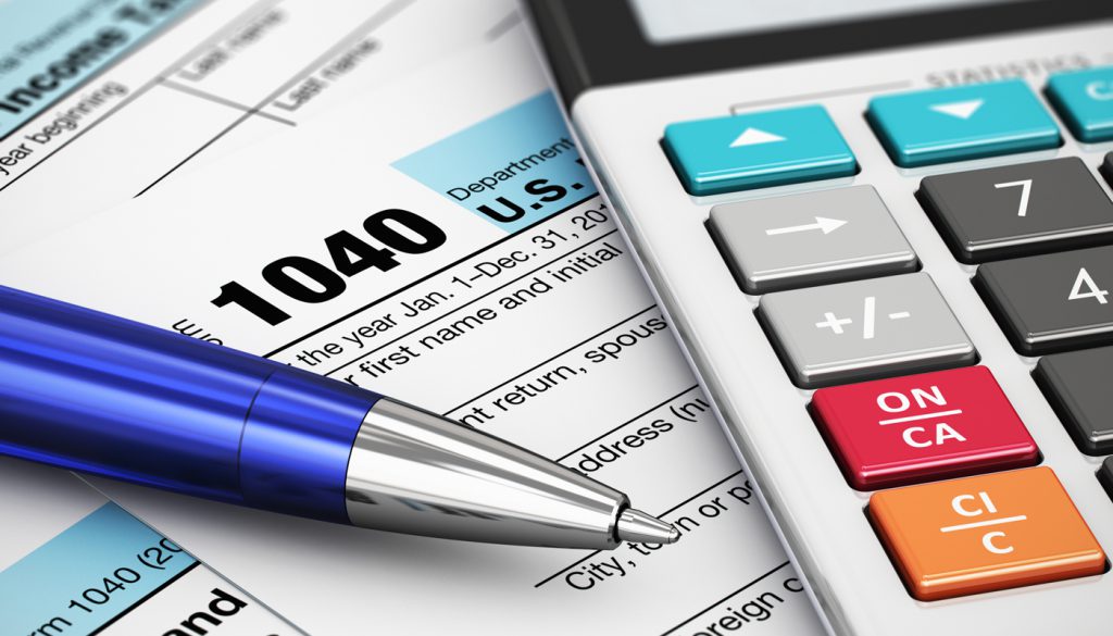 Macro view of 1040 US Tax Form, calculator and ballpoint pen