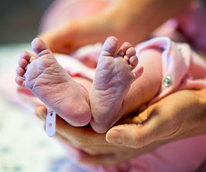 This is a photo of a parent holding a newborn's feet.