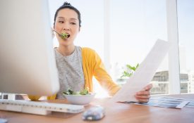Businesswoman eating a salad while working