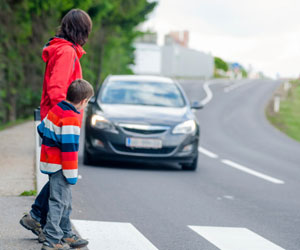 This is a photo of a mother and son at a pedestrian crossing.