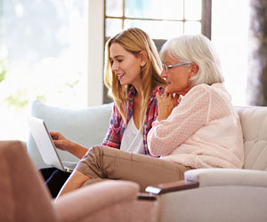 This is a photo of an older woman and a younger woman looking at a computer.