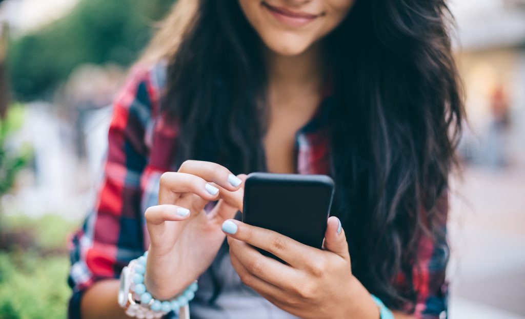 Teenage girl using smartphone at the street