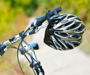 This is a photo of a bicycle helmet hanging from handlebars.