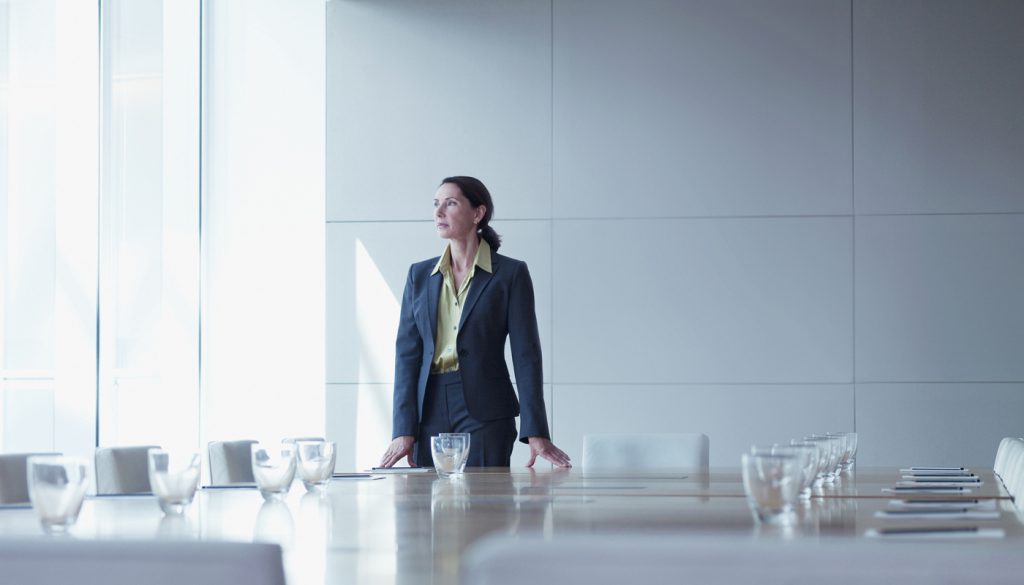 Businesswoman standing alone in conference room