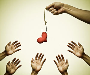 This is a photo of hands reaching toward a heart on a fishing line.