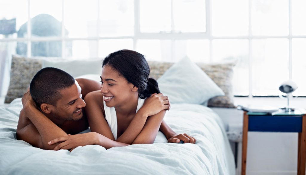 Happy-looking couple lying in bed