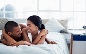 Happy-looking couple lying in bed