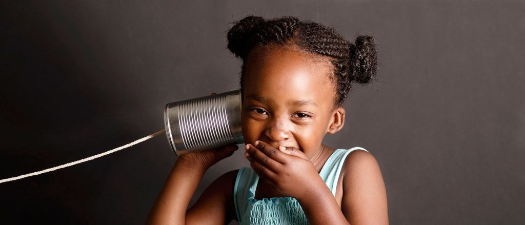 This is a photo of a girl "listening" to a tin can phone.