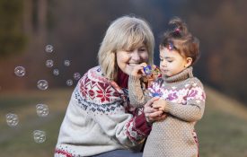 Grandmother and granddaughter blowing bubbles