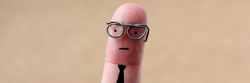 This is a photo of a pinky fingerwith drawn face, glasses, and tie.