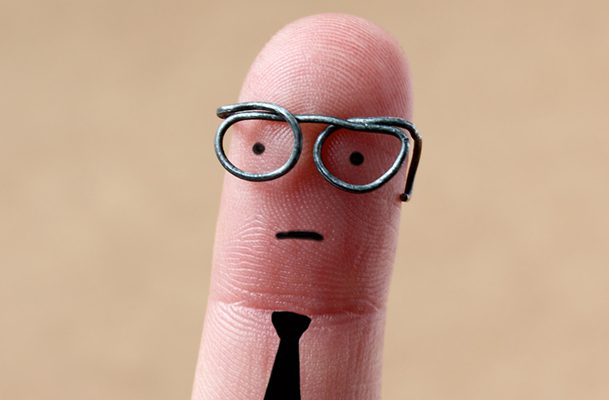 This is a photo of a pinky fingerwith drawn face, glasses, and tie.