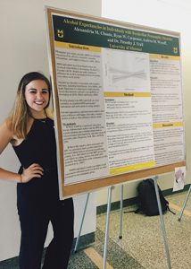 This is a photo of Allie Choate standing next to her poster at a research conference.