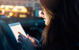 This is a photo of a woman using a tablet at night.