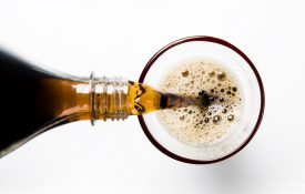 A glass of cola being poured into a glass