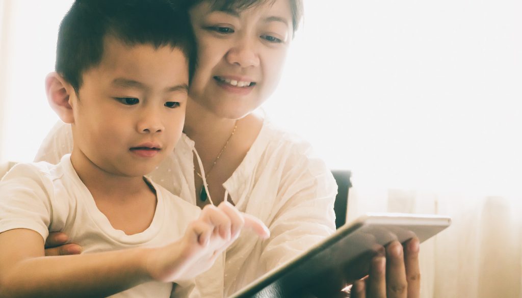 Mother and son using electronic tablet together.