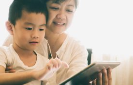 Mother and son using electronic tablet together.