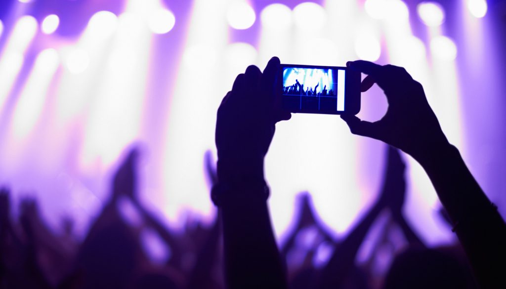 This is a photo of someone taking a cell phone photo of a band performing