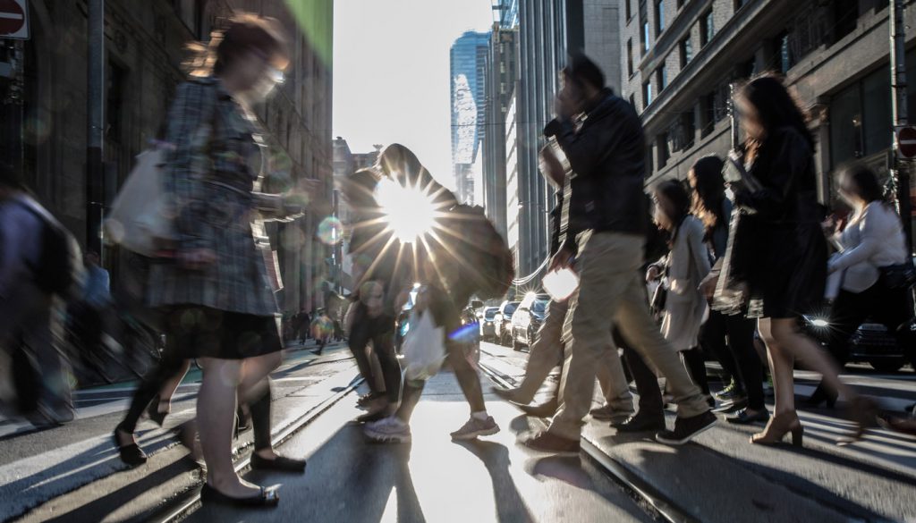 This is a photo of people crossing the street in a downtown area.