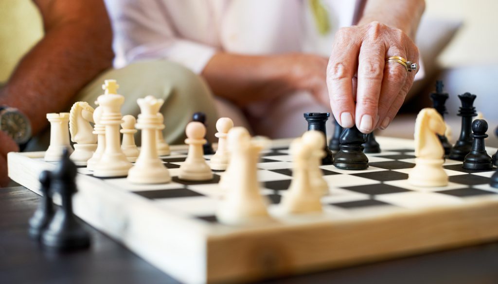 This is a cropped closeup of a senior couple enjoying a game of chess