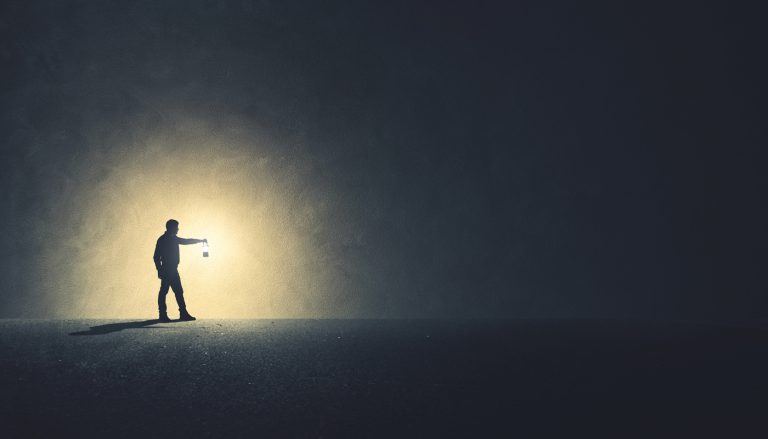 Man with lamp walking illuminating his path