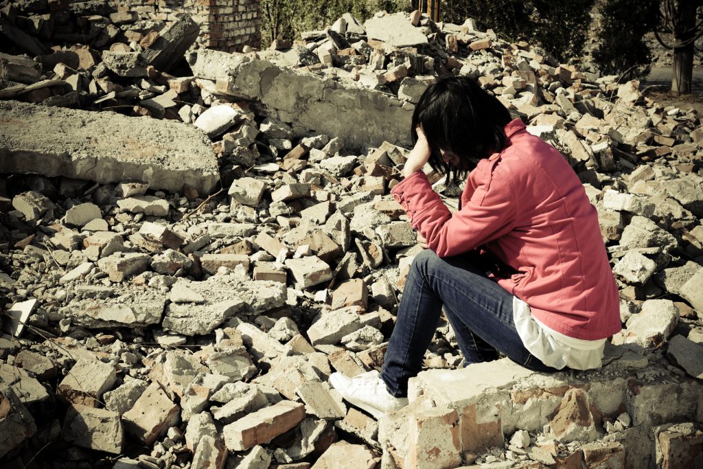 A homeless person is sitting on ground