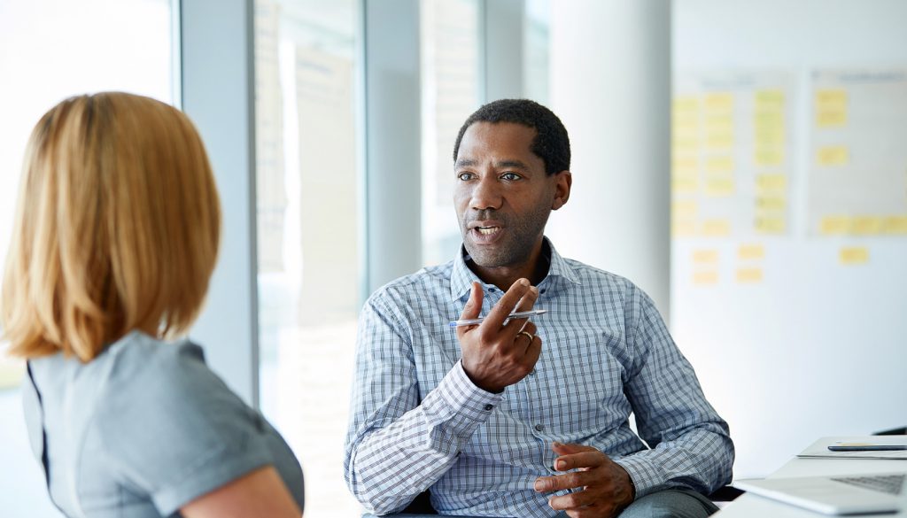 Shot of two colleagues talking together in a modern office