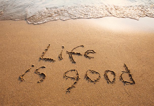 This is a photo of the words 'life is good' written on a beach