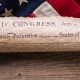 United States Declaration of Independence rolled in a scroll on a vintage American flag and rustic wooden board