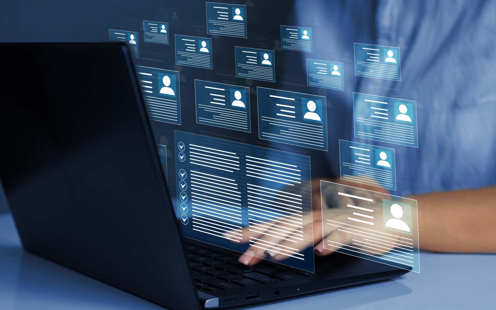 Business person working at laptop computer and digital documents with checkbox lists.