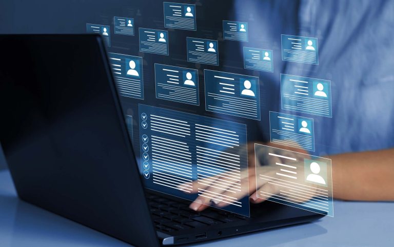 Business person working at laptop computer and digital documents with checkbox lists.