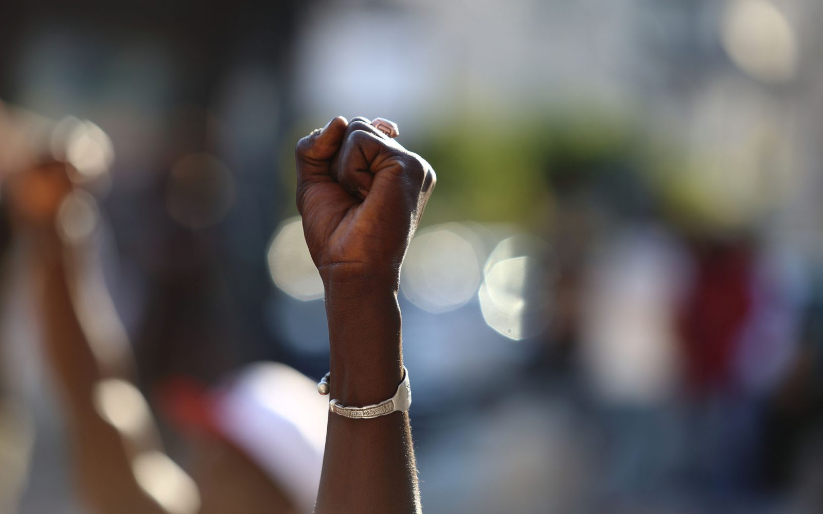 A Black person's hand raised into a fist.
