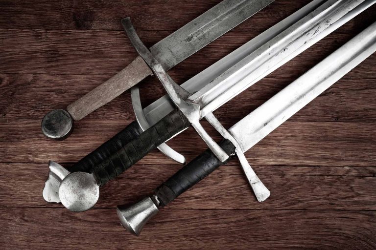 Four swords on a wooden background.